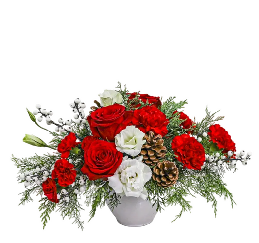 Bouquet of red and white flowers with greenery and pinecones in a gray vase on a white background